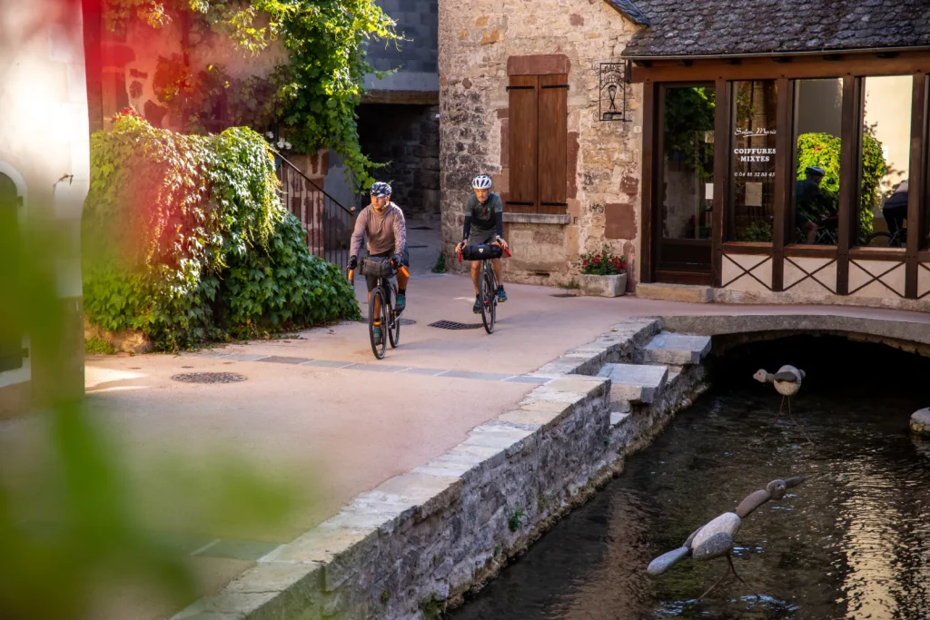 A gravel cyclist passing through La Canourgue on a cycle route through the Lot Valley.