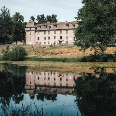 Château de la Baume se reflétant dans l'étang