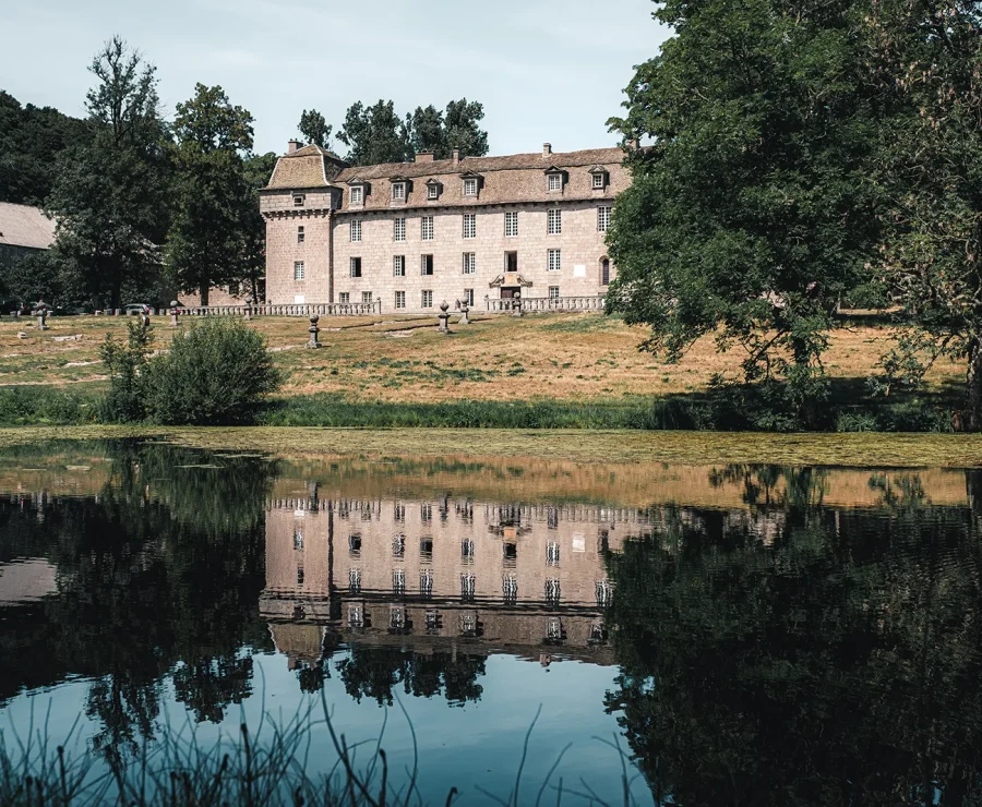 Château de la Baume se reflétant dans l'étang